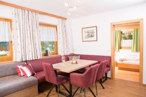 a dining room with a table and red chairs at Lochgrubgut in Altenmarkt im Pongau