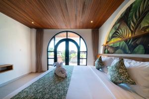 a bedroom with a bed with a stuffed animal on it at Tepi Segara Seminyak in Seminyak +34 photos