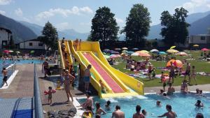 a crowd of people in a swimming pool with a slide at Appartementhaus Söllbacherhof in Fügen