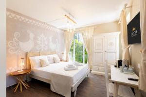 a bedroom with a white bed and a window at Eteria Luxury Rooms Spa & Wellness in Posada