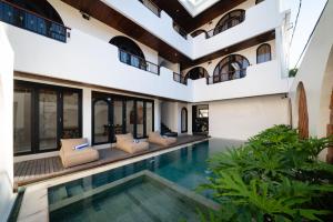 an indoor pool in a villa with a swimming pool at Tepi Segara Seminyak in Seminyak