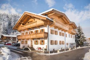 a large building with wooden balconies in the snow at Appartementhaus Söllbacherhof in Fügen
