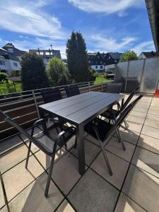 a wooden table and chairs on a roof at Mountain Lodge - Design Apartment in Winterberg