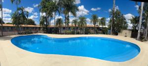 a large blue swimming pool in front of a building at Katherine Motel in Katherine +17 photos