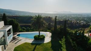 a villa with a swimming pool and a palm tree at Breathtaking view guesthouse in Psalidi
