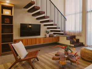 a living room with a staircase and a chair at Anandaya Sanur in Sanur
