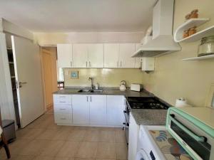 a kitchen with white cabinets and a sink at Mi petit Paraiso in San Isidro +17 photos