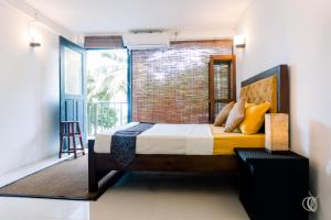a bedroom with a bed and a brick wall at Lavanga Express in Hikkaduwa