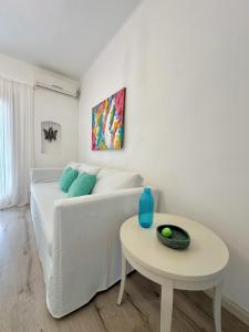a white bed and a table in a room at Mi petit Paraiso in San Isidro