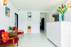 a living room with red furniture and a white wall at Lavanga Express in Hikkaduwa