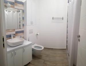 a white bathroom with a sink and a toilet at Studio zona centrala in Craiova