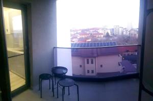 a room with three chairs and a window with a building at Studio zona centrala in Craiova