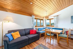 a living room with a couch and a wooden ceiling at Kesslerhütte Planai - by myNests in Schladming