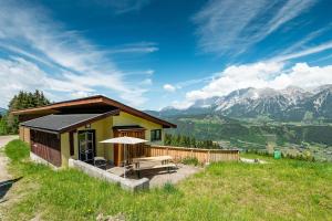 a small house on a hill with mountains in the background at Kesslerhütte Planai - by myNests in Schladming