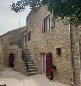 a stone building with stairs on the side of it at La terrasse des oiseaux in Taillet
