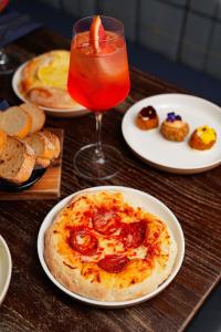 a table topped with plates of food and a drink at Riva Boutique Hotel in Helensburgh