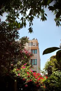 a tall building with pink flowers in front of it at Patron Hotel in Antalya