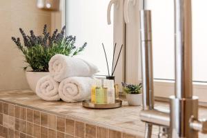 a bathroom counter with towels and candles and plants at Arabel Design Apartments in Berlin +68 photos