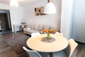 a white living room with a table and chairs at Alexa Apartament in Târgu-Mureş +26 photos
