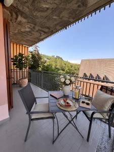 a patio with a table and chairs on a balcony at Elegant Penthouse LA BALCONATA - Wellness Retreat & Castle View in Tabiano
