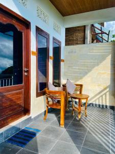 a porch with a bench and a chair on a house at De La Sierra in Munduk
