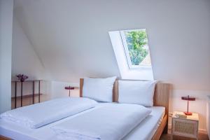 a bedroom with a bed with white sheets and a window at Reethaus Beusloe I in Beusloe