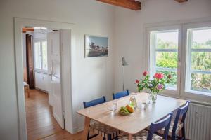 a dining room with a wooden table and blue chairs at Reethaus Beusloe II in Beusloe