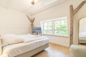 a white bedroom with a bed and a window at Strandvilla Lilli in Timmendorfer Strand
