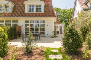 a patio with a table and chairs in front of a house at Strandvilla Lilli in Timmendorfer Strand