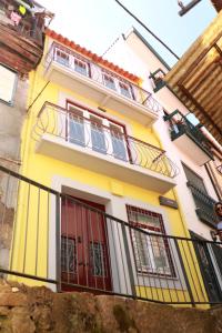 a yellow house with red doors and a balcony at Gaia River View in Vila Nova de Gaia +18 photos