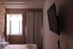 a bedroom with a bed and a television on a wall at Gaia River View in Vila Nova de Gaia