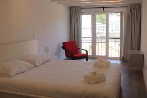 a bedroom with a bed and a red chair at Gaia River View in Vila Nova de Gaia