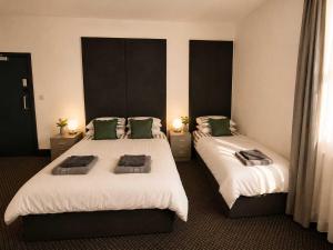 a hotel room with two beds with green pillows at GuestReady - The Hangman in Liverpool