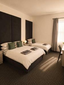 a hotel room with two beds and a window at GuestReady - The Hangman in Liverpool