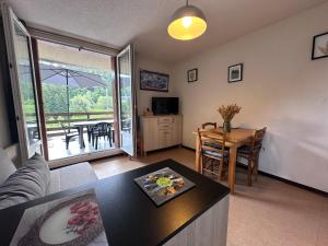 a living room with a couch and a table at Lioran - Le bonheur de Loustal in Laveissière