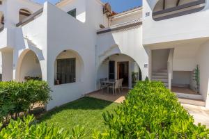 an external view of a house with white walls and a yard at Calma Menorca in Arenal d'en Castell