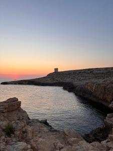 a body of water with a lighthouse in the background at Pembroke Suites in Pembroke