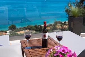 a bottle of wine sitting on a table with two glasses at Barbati breathtaking views in Barbati