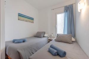 two beds in a room with blue pillows on them at Calma Menorca in Arenal d'en Castell +12 photos