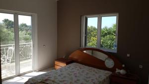 a bedroom with a bed and a mirror and windows at Villa Fotini III in Amalias