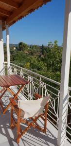 a wooden table and a chair on a balcony at Villa Fotini III in Amalias