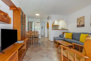 a living room with a blue couch and a tv at Calma Menorca in Arenal d'en Castell