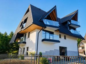 a house with a gambrel roof at Tatra Forest Apartments in Zakopane