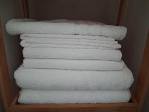 a stack of white towels in a closet at Ca' Dora in Otranto +2 photos