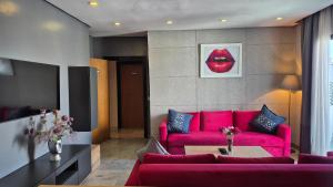 a living room with a pink couch and red lips at Suite Loc Suite & Spa in Casablanca