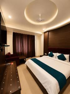 a bedroom with a large bed and a television at Hotel Krishna in Katra +31 photos