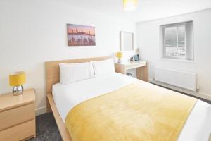 a bedroom with a bed with a yellow blanket on it at Skinningrove Beach Apartment 5 in Skinningrove