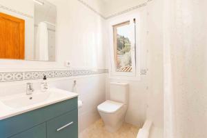 a white bathroom with a toilet and a sink at Can Cega in Bunyola +34 photos