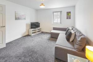 a living room with a couch and a tv at Skinningrove Beach Apartment 5 in Skinningrove