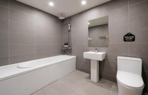 a bathroom with a tub and a toilet and a sink at Daily Motel in Incheon